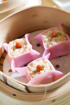 some food that is sitting in a wooden container on a table with chopsticks