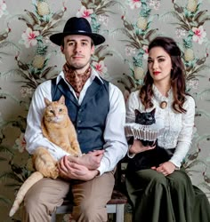 a man and woman sitting next to each other holding cats