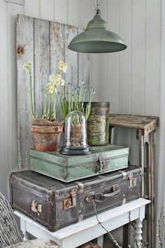 several old suitcases stacked on top of each other in front of a light fixture