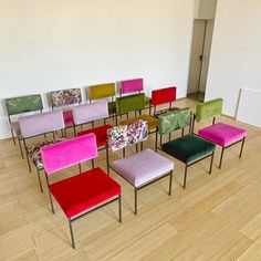 a group of colorful chairs sitting on top of a hard wood floor