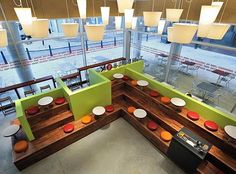 an overhead view of a restaurant with green booths and white plates on the counter top