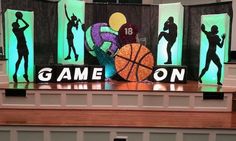 an image of a game on stage with basketballs and people silhouetted behind it