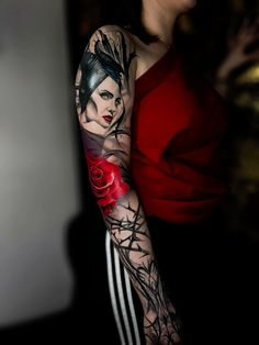 a woman with a tattoo on her arm and shoulder is holding a red rose in her left hand