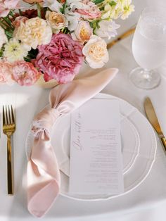 a table setting with pink and white flowers