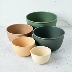 four different colored bowls sitting on top of a table