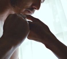 a man is brushing his teeth in front of a window