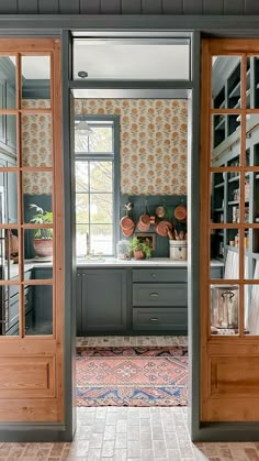 an open door leading to a kitchen with pots and pans on the wall