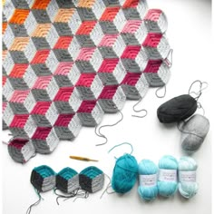 crochet and knitting supplies are laid out on a table with the yarns in different colors