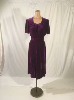 "vintage 1940s handmade dress solid purple  soft velvet side zip- metal TALON side belt loops matching sash tie belt scoop neck w/pleats good vintage condition, light wear measures, lying flat, shoulder-14 1/2\" chest-18 1/2\" waist-12\" hip-18\" to 19\" sleeve-9\" top shoulder to waist-16\" total length-44 1/2\"     We do not offer returns or refunds unless something is grossly misrepresented. Please contact us within 2 business days of receiving to discuss any possible returns for this reason. We do not offer refunds for your shipping fees. Please feel free to contact us with any questions you may have about an item prior to purchase and we will gladly answer them." Purple 50s Dress, Fitted Belted Purple Dress, Side Belt, Purple Soft, Vintage 40s, Handmade Dress, Scoop Neck Dress, 1940s Dresses, Purple Blouse