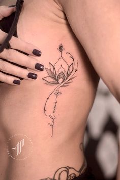 a woman's stomach with a lotus tattoo on it and the words love written in cursive writing