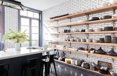 a kitchen filled with lots of counter top space next to a wall covered in shelves