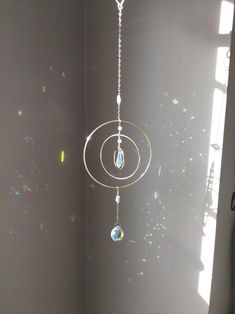 a wind chime hanging in the corner of a room with sunlight shining on it