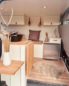 the interior of a tiny home with wood flooring and white walls, including shelves