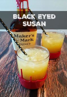 two glasses filled with liquid sitting on top of a wooden table