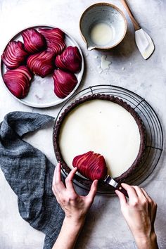 a person cutting up some food on top of a table next to bowls and spoons