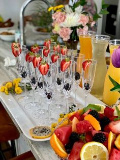 a table topped with lots of glasses filled with fruit