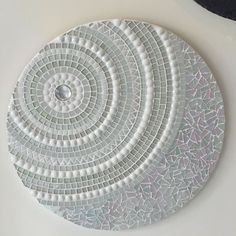 a white plate sitting on top of a table next to a black and white clock