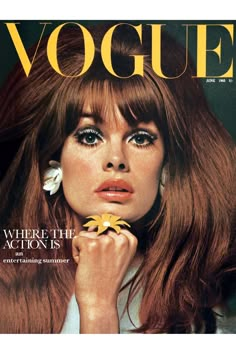 a woman with long red hair and flower in her hand on the cover of a magazine