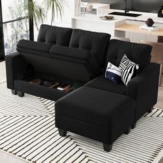 a living room with a black couch and ottoman