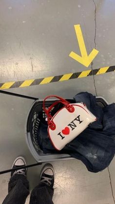 a person standing next to a luggage bag on top of a metal floor with an arrow pointing up