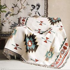 a blanket is draped on top of a chair in front of two wall hangings