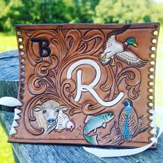 a leather wallet with the letter r painted on it's front and two birds