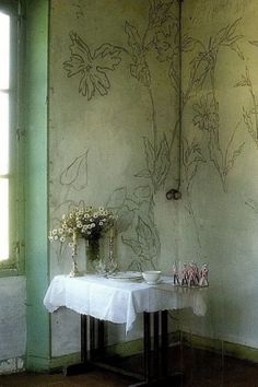 a table with flowers on it in front of a wall