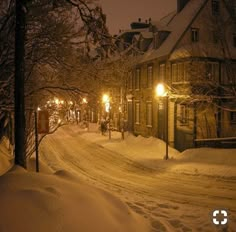 a street is covered in snow at night