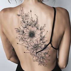 the back of a woman's body with flowers on her shoulder and lower back