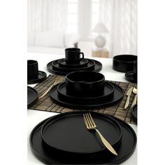 a table set with black plates and silverware