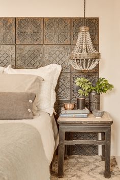 a bedroom with a bed, nightstand and chandelier on the wall above it