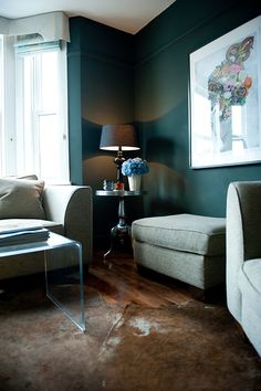 a living room filled with furniture and a painting on the wall