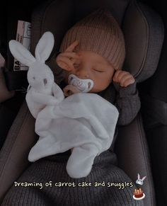 a baby sleeping in a car seat wearing a bunny costume