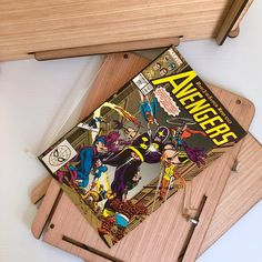 two wooden cutting boards with comic covers on them