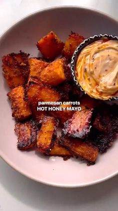 a white plate topped with fried potatoes and dipping sauce next to a bowl of mayonnaise