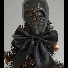 a skull with a bow on top of a christmas tree