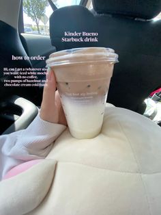 a person holding up a drink in the back seat of a car with information about it