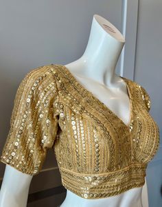 A golden color blouse Product details Fabric - silk blend Embroidery - sequins Bust size 36" Waist 30" sleeve length 10" Can be tailored to fit 38" For extra charges Golden Heavy Blouse, Blouse Designs Golden Color, Fitted V-neck Sequin Blouse, Fitted Sequined V-neck Blouse, Festive V-neck Evening Blouse, Elegant Gold Blouse Piece With Mirror Work, Embellished V-neck Blouse For Reception, Gold V-neck Blouse For Wedding, Fitted V-neck Blouse With Mirror Work