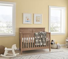 a baby's room with yellow walls and furniture