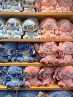 many different colored stuffed animals are on shelves in a toy store, one is blue and the other is pink