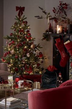 a living room decorated for christmas with red and gold decorations