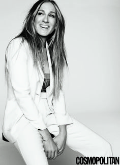 a woman sitting on top of a white floor next to a black and white photo