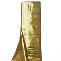 a tall gold vase sitting on top of a table