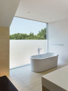 a large white bath tub sitting next to a window