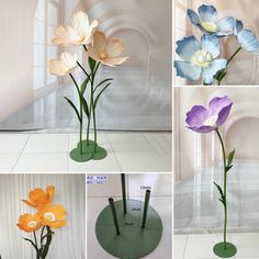 four different colored flowers in vases on display