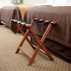 a bed room with two beds and a wooden tray on the ground next to it