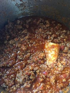 a pot filled with meat and sauce on top of a stove