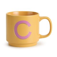 a yellow coffee mug with the letter c painted on it's front and side