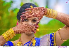 a woman with her hands on her face and arms covered in henna, posing for the camera