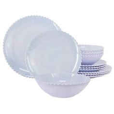 a set of white dishes with scalloped rims